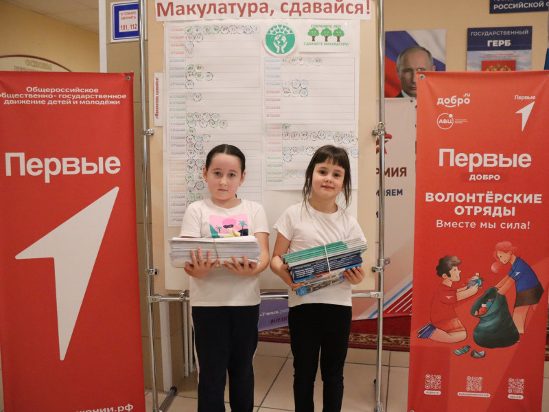 Учащиеся нашей школы держат собранную макулатуру.